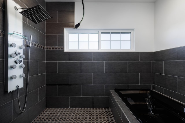 bathroom featuring tiled shower and a wealth of natural light