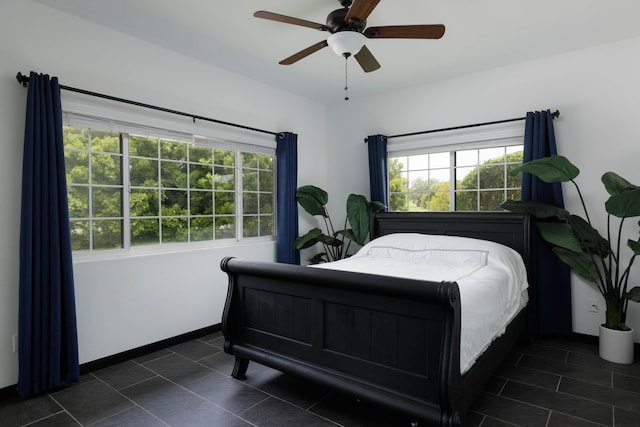 bedroom featuring ceiling fan, baseboards, and dark tile patterned flooring