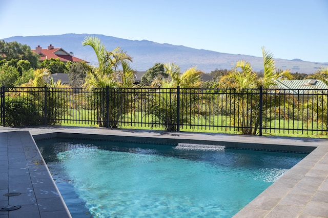 view of swimming pool with a mountain view, fence, and a fenced in pool