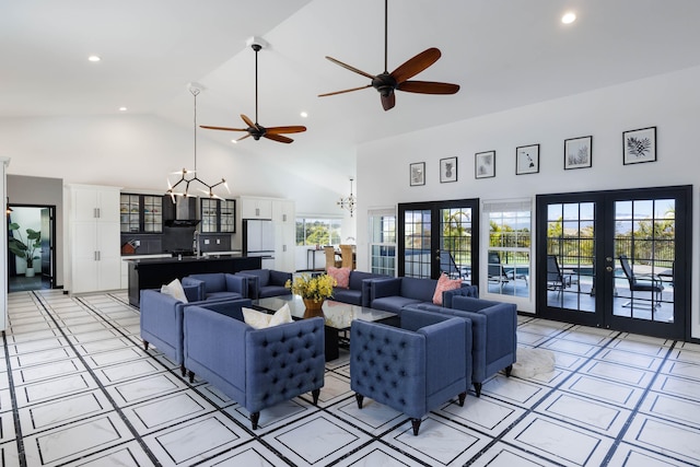 living area with high vaulted ceiling, ceiling fan with notable chandelier, french doors, and recessed lighting