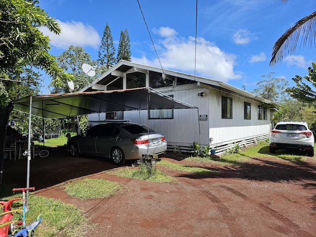 view of side of home with a carport and driveway