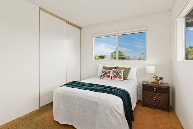 bedroom with light carpet and a closet