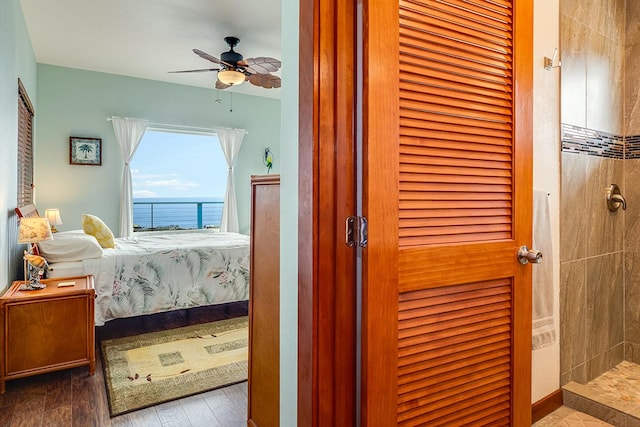 bedroom featuring a water view and wood finished floors