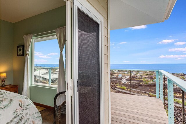 bedroom with baseboards, a water view, wood finished floors, and a closet