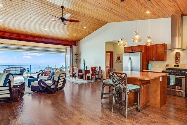kitchen featuring ceiling fan, wall chimney range hood, light countertops, wooden ceiling, and stainless steel appliances