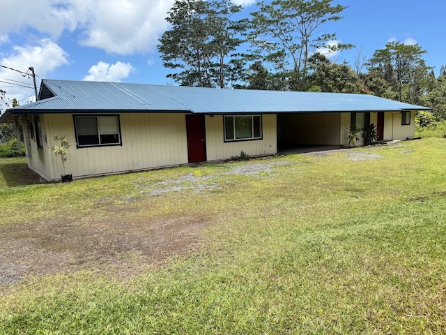 view of front facade with metal roof, an attached carport, and a front lawn