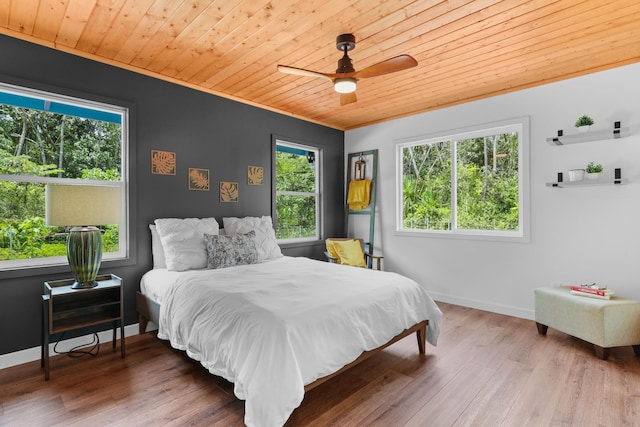 bedroom with wood ceiling, ornamental molding, wood finished floors, baseboards, and a ceiling fan