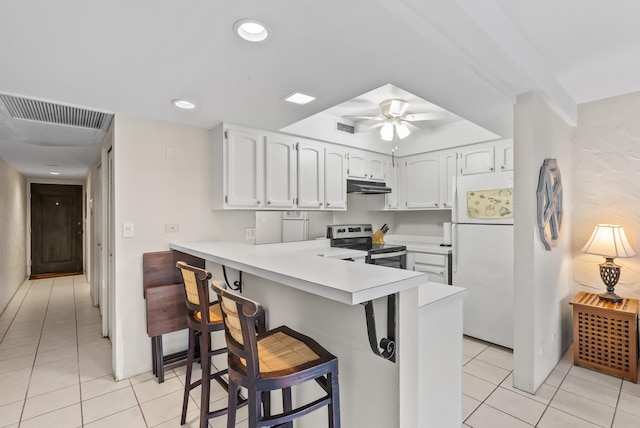75-6082 Alii Dr Unit A103, Kailua-Kona, HI 96740 - kitchen with freestanding refrigerator, stainless steel electric range oven, light tile patterned floors, under cabinet range hood, and a peninsula
