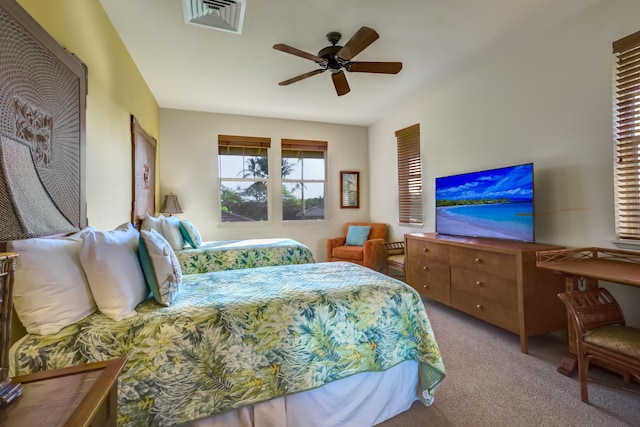 carpeted bedroom with a ceiling fan and visible vents