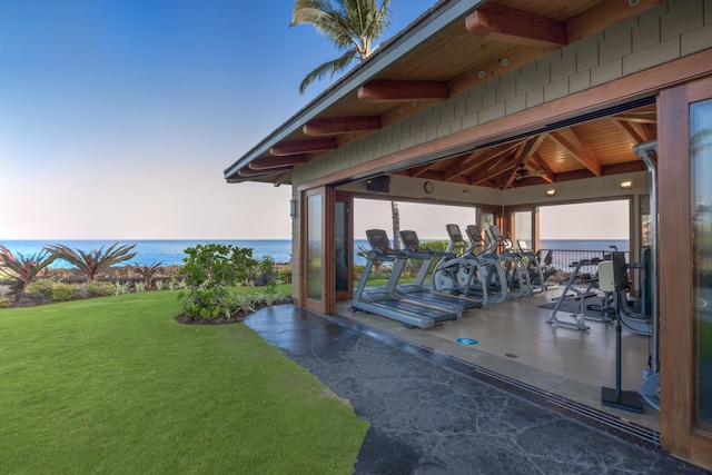 exercise room featuring a water view and wood ceiling