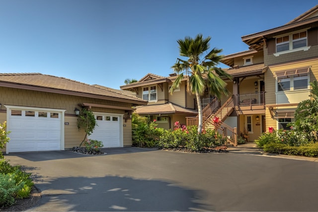 view of front of property featuring an attached garage, stairway, and concrete driveway