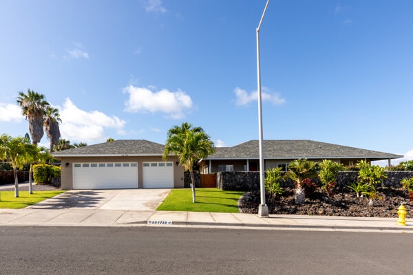 single story home with an attached garage, driveway, and a front lawn
