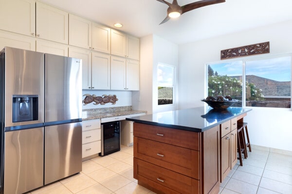 kitchen featuring stainless steel fridge, light tile patterned floors, ceiling fan, and white cabinetry