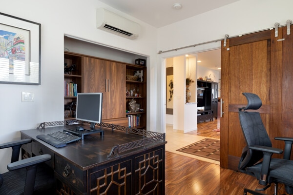 home office featuring a wall unit AC and wood finished floors