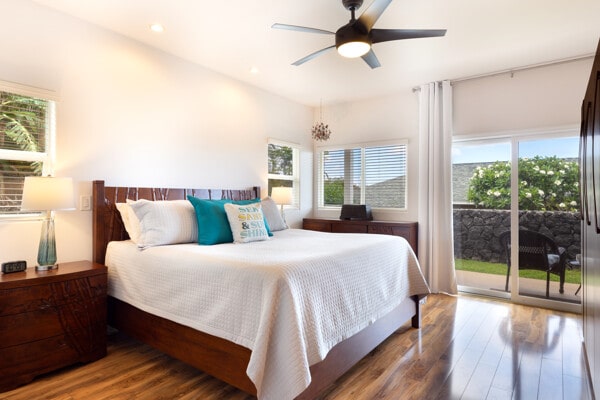 bedroom with multiple windows, wood finished floors, and access to exterior
