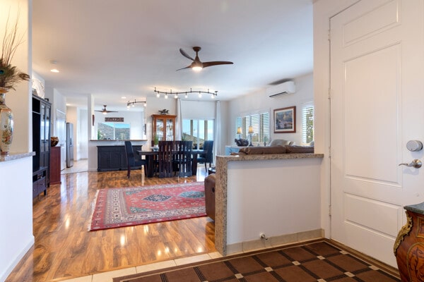 foyer with a ceiling fan and a wall mounted AC