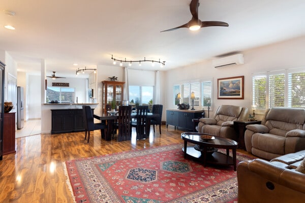 living room with an AC wall unit, a ceiling fan, a healthy amount of sunlight, and wood finished floors