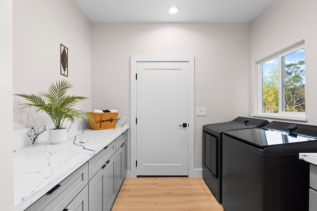 laundry room featuring washer and clothes dryer, light wood-style flooring, cabinet space, and recessed lighting