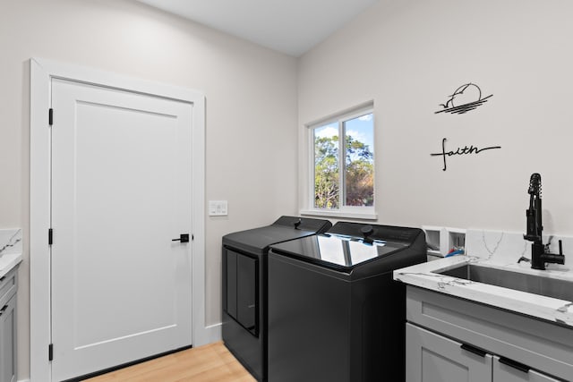 washroom featuring cabinet space, separate washer and dryer, and light wood-type flooring