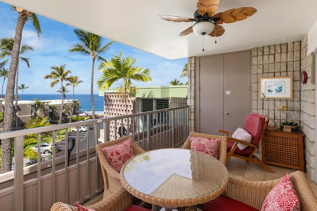 balcony featuring a water view and a ceiling fan