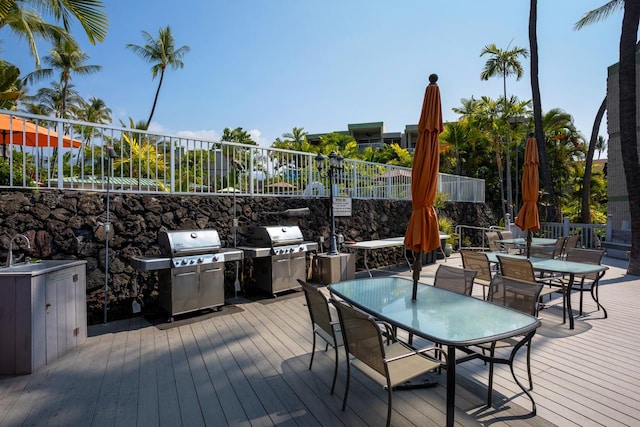 wooden deck featuring a fenced backyard, area for grilling, and outdoor dining space
