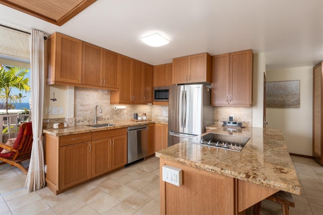 kitchen featuring a sink, light stone countertops, appliances with stainless steel finishes, decorative backsplash, and light tile patterned flooring