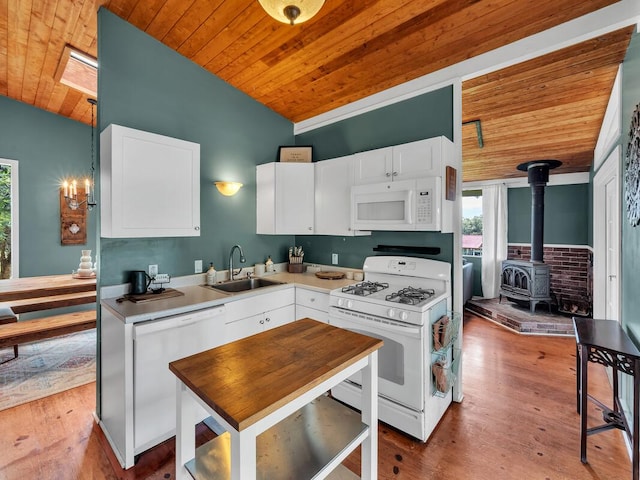 kitchen featuring white appliances, wooden ceiling, a sink, lofted ceiling, and healthy amount of natural light