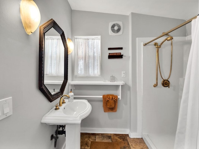 bathroom with curtained shower and baseboards