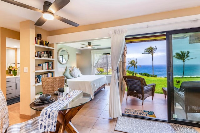 tiled bedroom with access to exterior, ceiling fan, and a water view