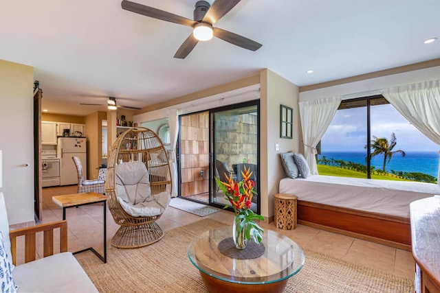 bedroom featuring light tile patterned floors, access to exterior, a water view, and freestanding refrigerator