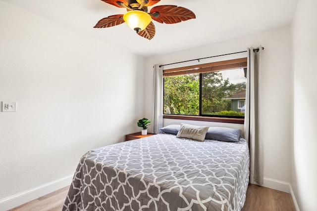bedroom featuring baseboards, ceiling fan, and wood finished floors