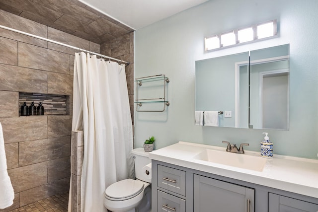 bathroom featuring vanity, toilet, and tiled shower
