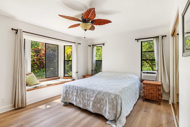 bedroom featuring baseboards, ceiling fan, and light wood-style floors