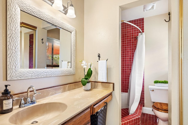 bathroom featuring vanity, tile patterned flooring, toilet, and tiled shower