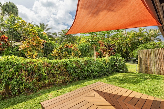 deck featuring a lawn, fence, and a gate