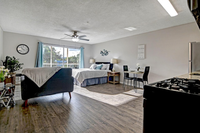 355 Kalanianaole St Unit 225, Hilo, HI 96720 - bedroom featuring a textured ceiling, freestanding refrigerator, a ceiling fan, and wood finished floors
