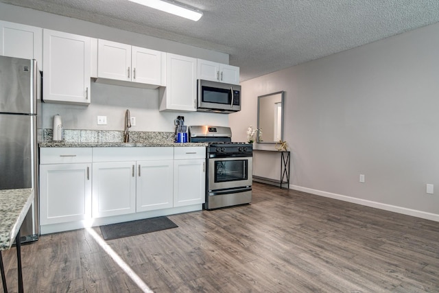 355 Kalanianaole St Unit 225, Hilo, HI 96720 - kitchen featuring white cabinets, appliances with stainless steel finishes, a sink, baseboards, and dark wood-style floors