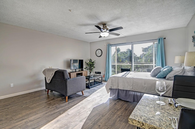 355 Kalanianaole St Unit 225, Hilo, HI 96720 - bedroom with a textured ceiling, ceiling fan, dark wood-style floors, and baseboards