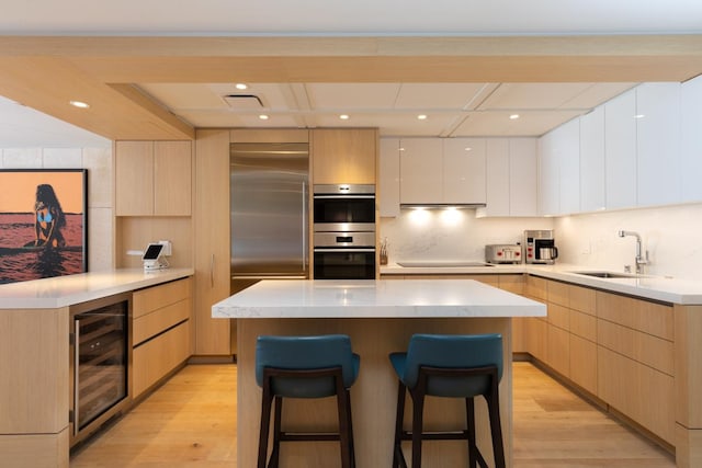66-84 Kaunaoa Dr Unit A21, Kamuela, HI 96743 - kitchen with a sink, wine cooler, appliances with stainless steel finishes, modern cabinets, and light wood-style floors