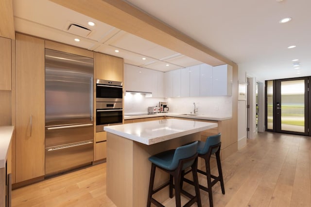 66-84 Kaunaoa Dr Unit A21, Kamuela, HI 96743 - kitchen featuring built in fridge, modern cabinets, stainless steel double oven, a kitchen bar, and light countertops