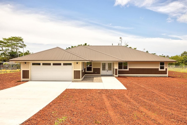 ranch-style home featuring french doors, metal roof, a garage, fence, and concrete driveway