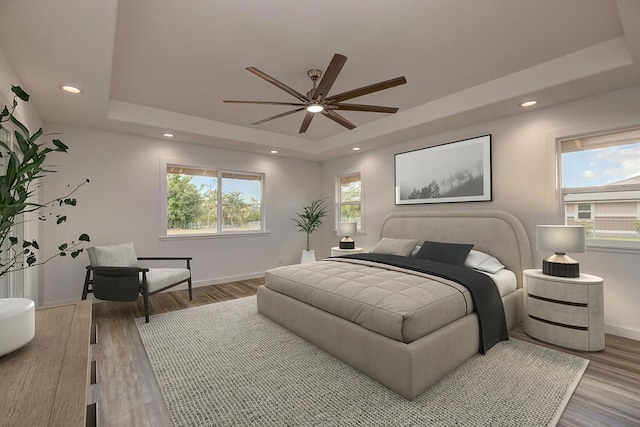 bedroom featuring wood finished floors, baseboards, ceiling fan, recessed lighting, and a tray ceiling