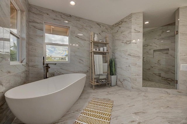 bathroom featuring a freestanding tub, tile walls, a marble finish shower, and marble finish floor