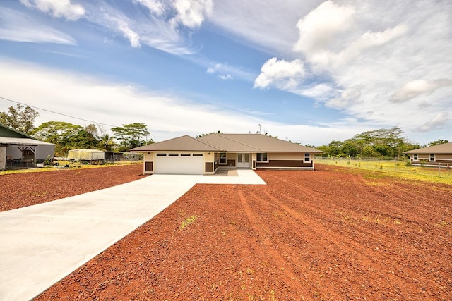 ranch-style house featuring fence, driveway, and a garage