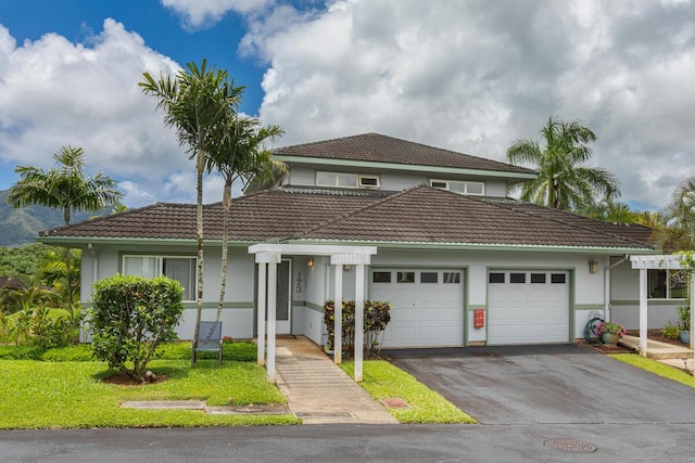 2110 Kaneka St Unit 73, Lihue, HI 96766 - view of front of property featuring a tile roof, an attached garage, stucco siding, and driveway