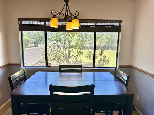 dining space featuring healthy amount of natural light, baseboards, and a chandelier