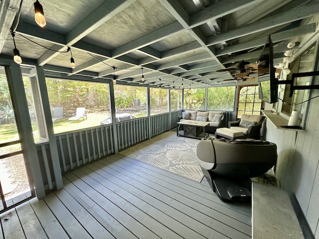sunroom featuring outdoor lounge area, a ceiling fan, and healthy amount of natural light