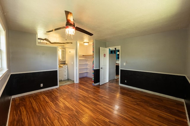 empty room with baseboards, ceiling fan, and wood finished floors