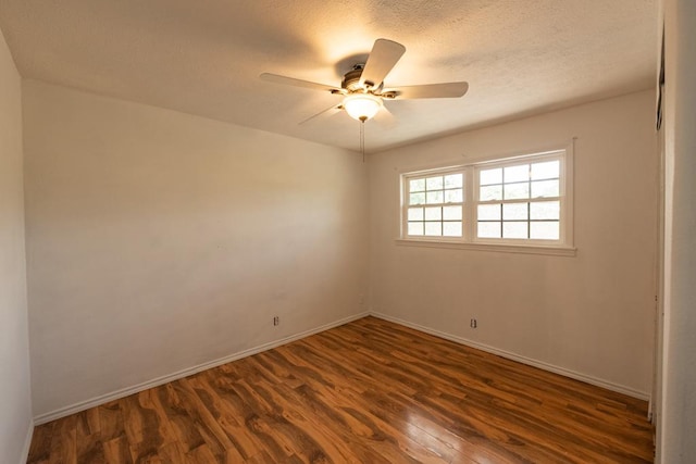 spare room with dark wood-type flooring, baseboards, and ceiling fan