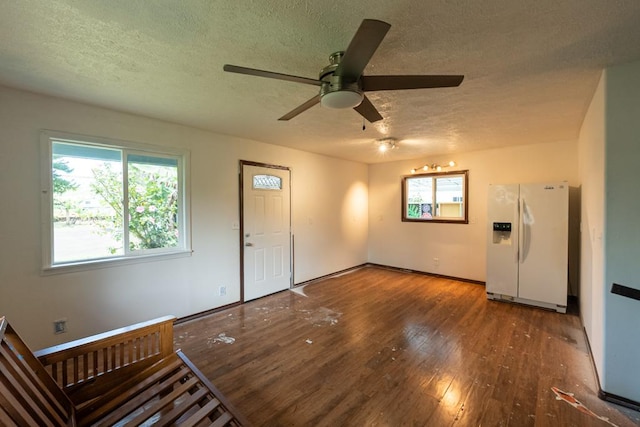 interior space with hardwood / wood-style flooring, a textured ceiling, baseboards, and a ceiling fan